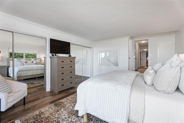 bedroom with multiple closets and wood finished floors