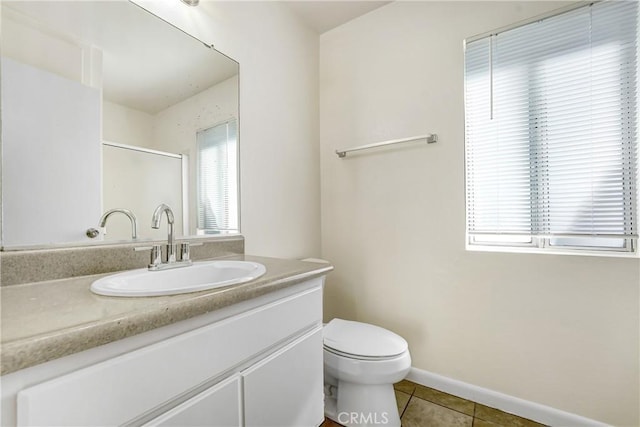 full bathroom featuring a shower with door, toilet, vanity, baseboards, and tile patterned floors