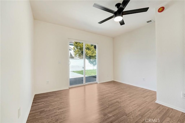 empty room with visible vents, baseboards, and wood finished floors