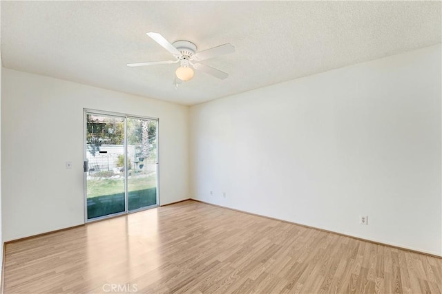 empty room featuring a textured ceiling, ceiling fan, and wood finished floors