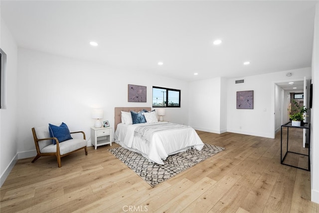 bedroom featuring baseboards, light wood-type flooring, visible vents, and recessed lighting