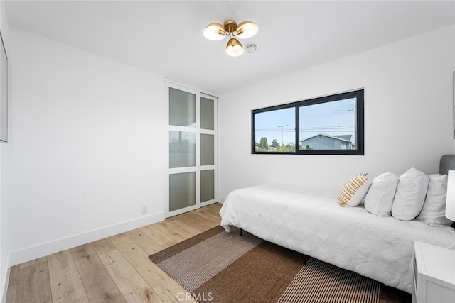 bedroom featuring baseboards and light wood finished floors