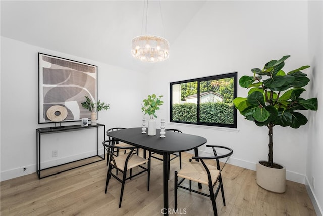 dining area with a chandelier, light wood-type flooring, and baseboards