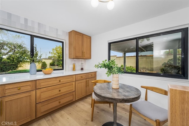 kitchen featuring light countertops, brown cabinetry, and light wood-type flooring