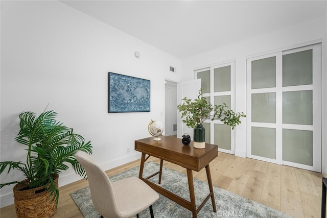 home office with light wood-type flooring and baseboards