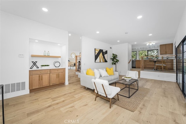 living area featuring light wood-type flooring, stairway, visible vents, and recessed lighting