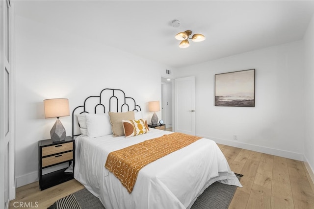 bedroom featuring baseboards and light wood finished floors