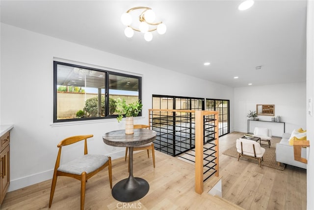 living area featuring a notable chandelier, recessed lighting, light wood-style floors, an upstairs landing, and baseboards