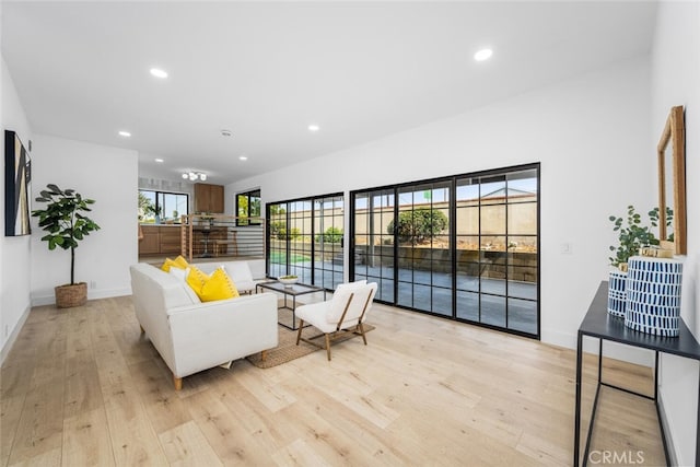 living area featuring light wood-style floors, baseboards, and recessed lighting