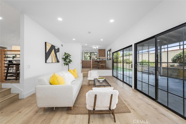 living area featuring light wood-type flooring, stairway, baseboards, and recessed lighting