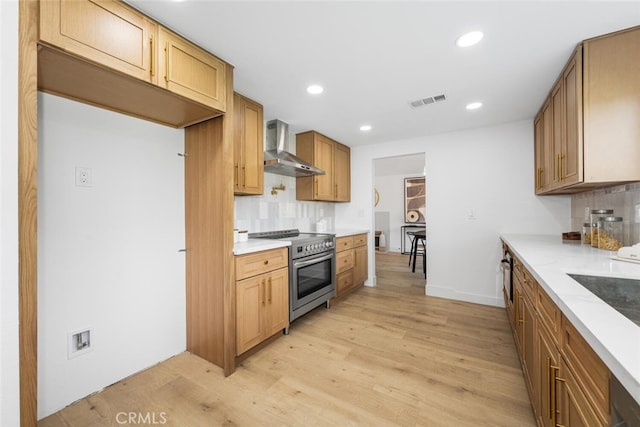 kitchen with electric range, wall chimney range hood, visible vents, and tasteful backsplash