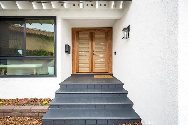 property entrance with stucco siding