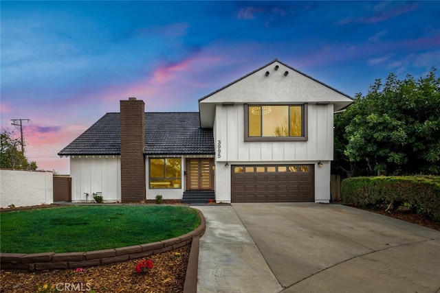 view of front of property with a chimney, an attached garage, board and batten siding, fence, and driveway