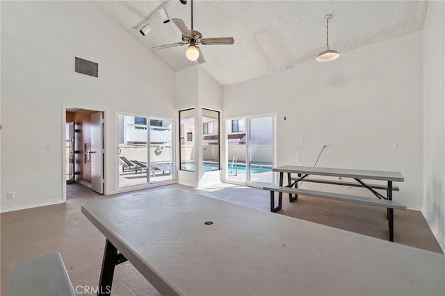 playroom with a textured ceiling, high vaulted ceiling, visible vents, and baseboards