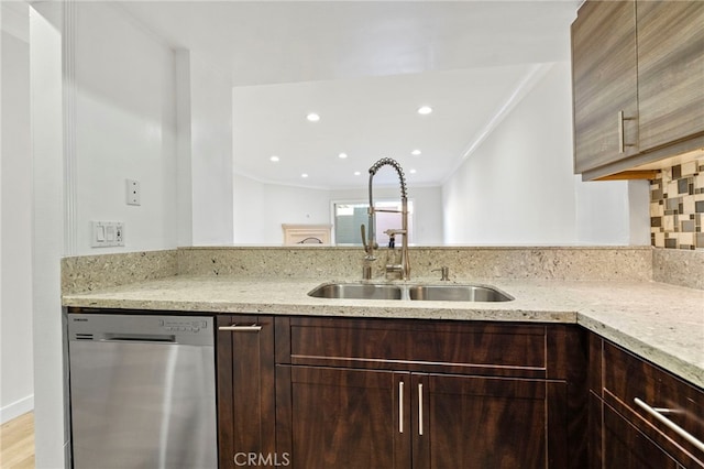 kitchen with tasteful backsplash, dishwasher, light stone counters, crown molding, and a sink