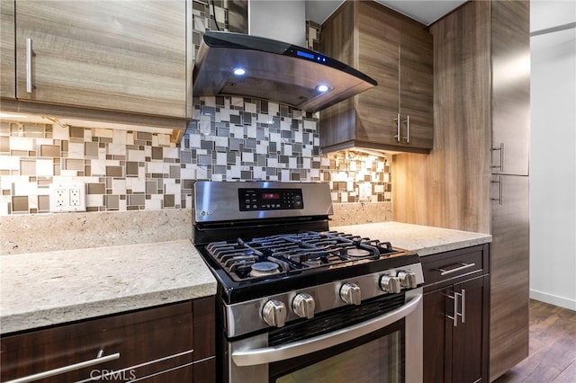 kitchen featuring range hood, dark brown cabinetry, stainless steel gas range oven, and decorative backsplash