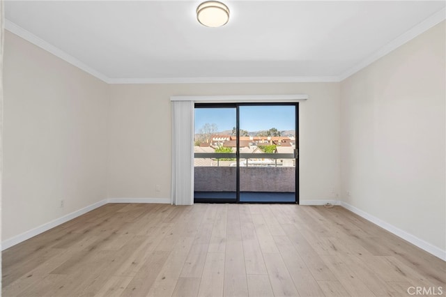 empty room featuring crown molding, light wood-style flooring, and baseboards