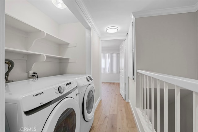 washroom with ornamental molding, laundry area, independent washer and dryer, and light wood-style flooring