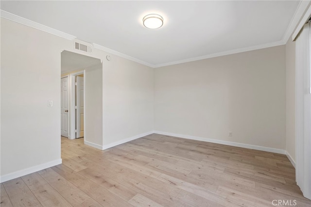 unfurnished room featuring light wood-style flooring, visible vents, ornamental molding, and baseboards