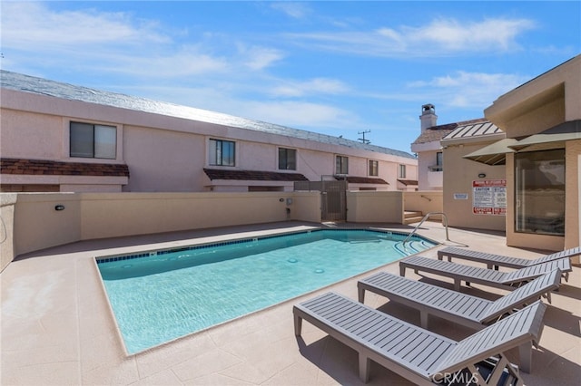 pool with fence and a patio