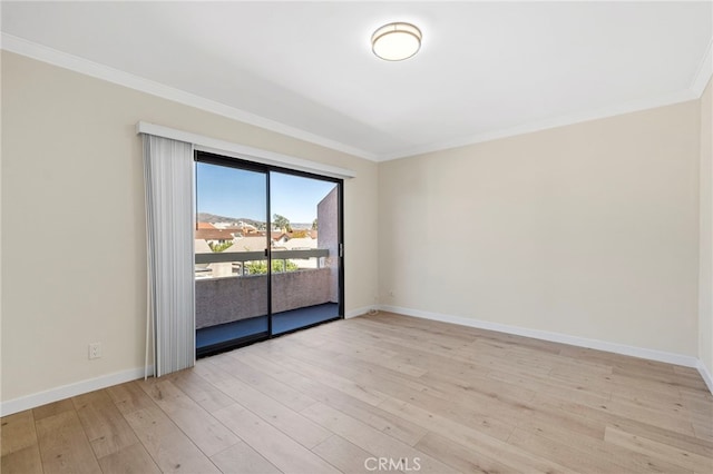 empty room with light wood-style floors, baseboards, and crown molding