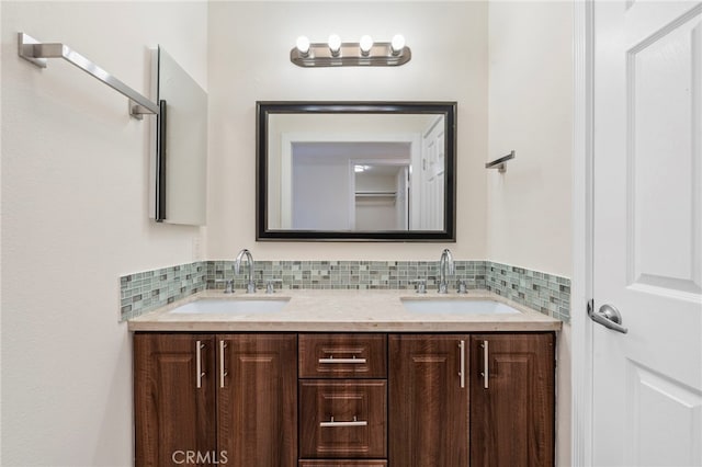 full bathroom featuring a sink, backsplash, and double vanity