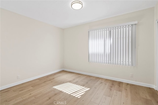 empty room featuring baseboards and hardwood / wood-style floors