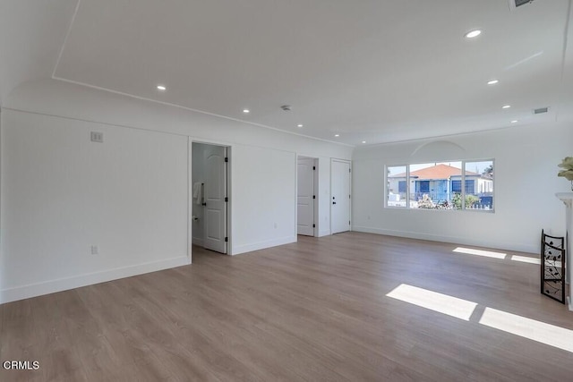 unfurnished living room with baseboards, wood finished floors, and recessed lighting