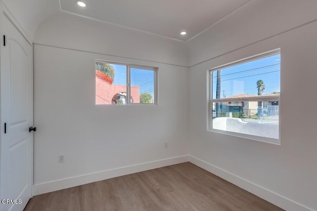 unfurnished room featuring recessed lighting, wood finished floors, and baseboards