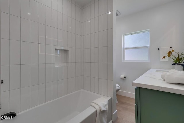 full bathroom featuring shower / tub combination, toilet, wood finished floors, vanity, and baseboards