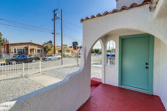 exterior space featuring a residential view, fence, and stucco siding