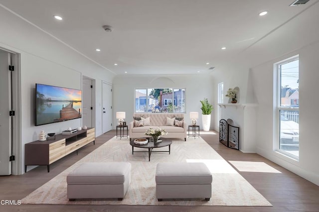 living room featuring visible vents, recessed lighting, a fireplace, and wood finished floors