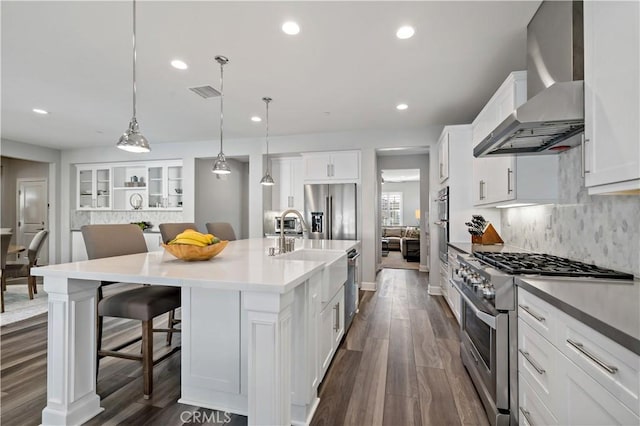 kitchen with recessed lighting, dark wood-style flooring, visible vents, appliances with stainless steel finishes, and wall chimney exhaust hood