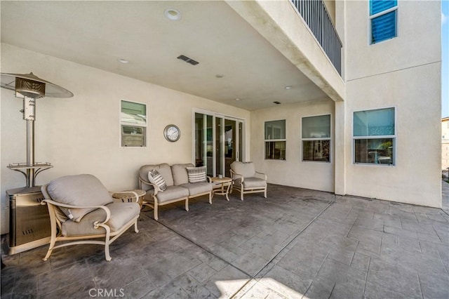 view of patio with outdoor lounge area and visible vents