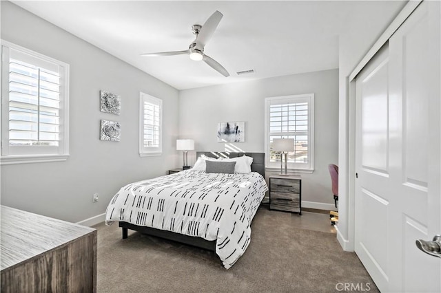 carpeted bedroom featuring visible vents, baseboards, and multiple windows