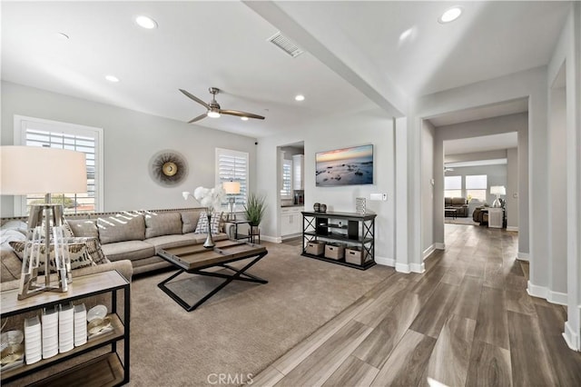 living area featuring recessed lighting, visible vents, and baseboards