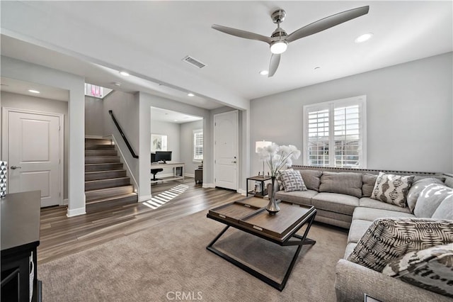 living room featuring recessed lighting, visible vents, stairway, and wood finished floors