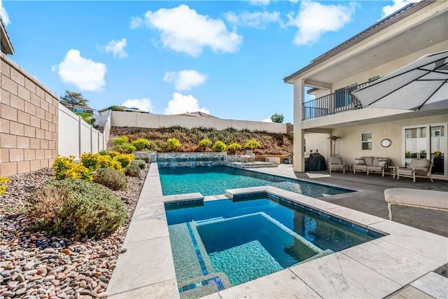 view of swimming pool with a patio, a fenced backyard, an outdoor hangout area, a pool with connected hot tub, and grilling area