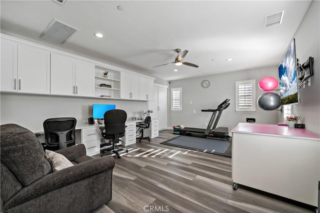 office area with recessed lighting, wood finished floors, visible vents, a ceiling fan, and built in desk