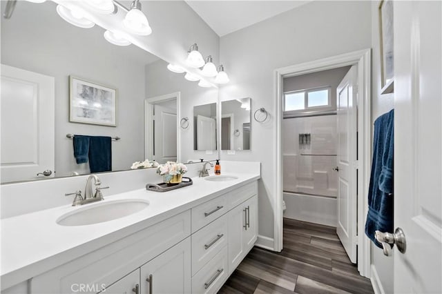 full bath with wood finished floors, a sink, toilet, and double vanity