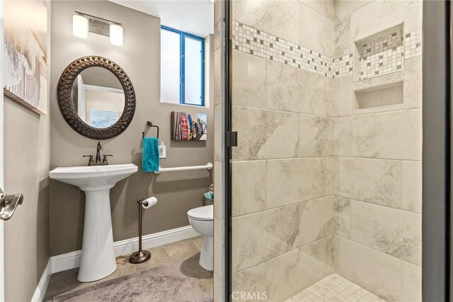 full bath with baseboards, toilet, and a stall shower