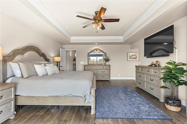 bedroom with ornamental molding, a raised ceiling, and wood finished floors