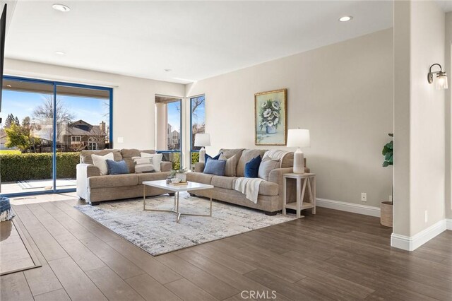 living area with recessed lighting, wood finished floors, and baseboards