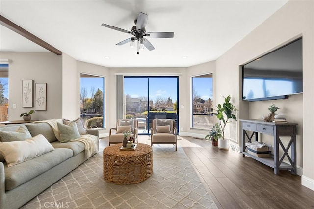 living room featuring a ceiling fan, baseboards, and wood finished floors