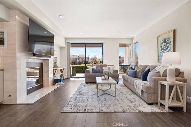 living room with baseboards, recessed lighting, hardwood / wood-style floors, and a premium fireplace