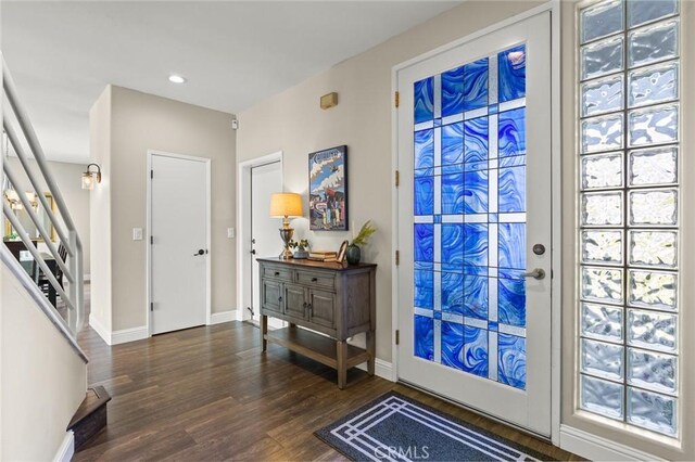 entryway with baseboards, wood finished floors, recessed lighting, and stairs