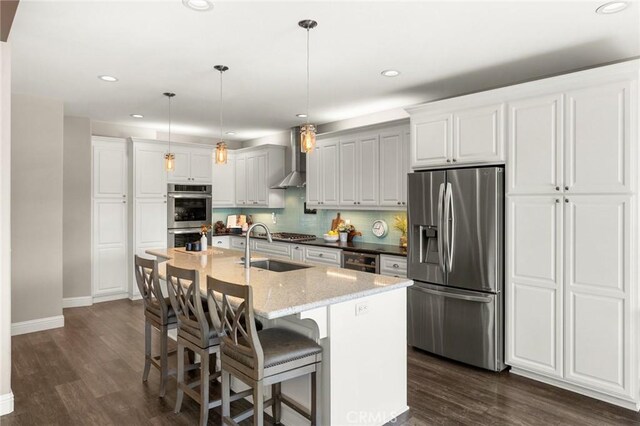 kitchen with recessed lighting, dark wood finished floors, stainless steel appliances, a sink, and baseboards