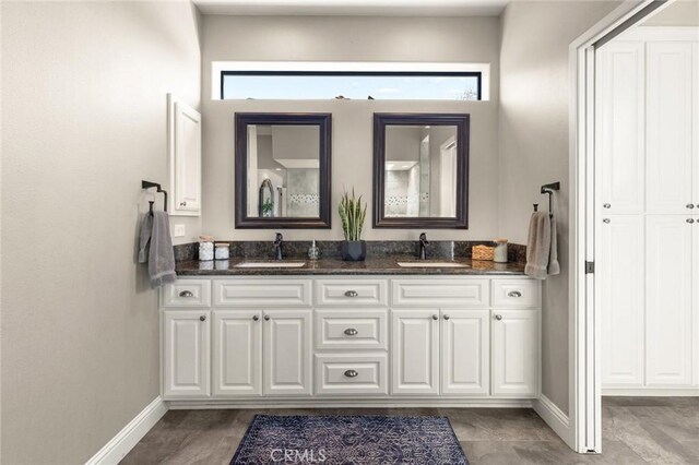 bathroom featuring a wealth of natural light, baseboards, and a sink