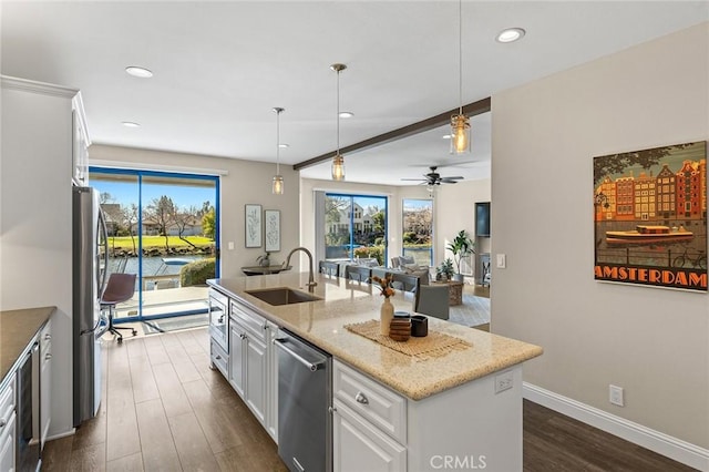 kitchen with a sink, white cabinetry, a healthy amount of sunlight, appliances with stainless steel finishes, and dark wood-style floors