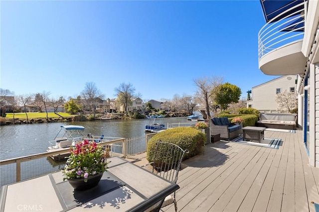 wooden deck featuring a dock, a water view, and a residential view